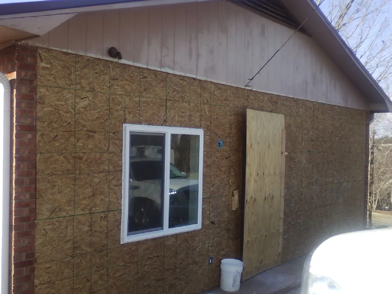 OSB sheathing on a garage addition wall before siding in Hart
