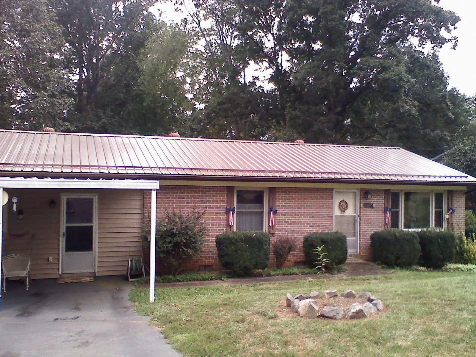Bronze metal roof and carport on a brick ranch home — Roof Repair work by our crew in Hart