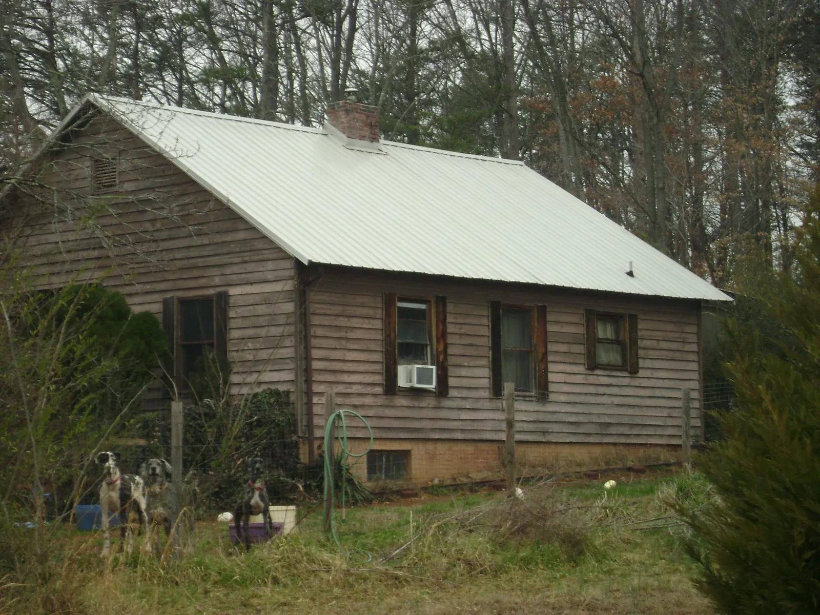 White metal roof on an old wood sided farmhouse, from a Metal Roof Installation job in Hart